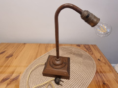 Alte Werkstattleuchte aus den 1930er bis 1950er Jahren, Metallarm und Fassung stark patiniert, typisch für Vor- oder Nachkriegsleuchten, stoffummanteltes Kabel mit altem Bakelit-Stecker